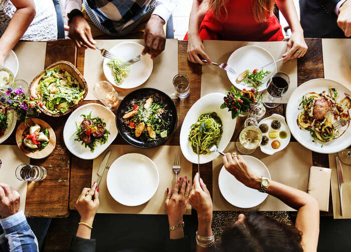 A group of people dine family-style at a table